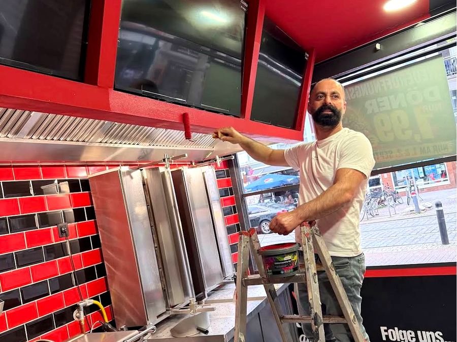 Person streicht die rote Decke über der Grillstation während der Vorbereitungen
